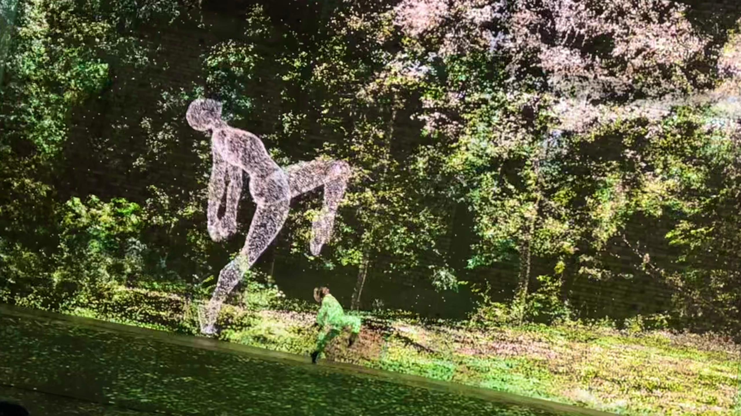 Motion-capture visual of a large human figure against a forest