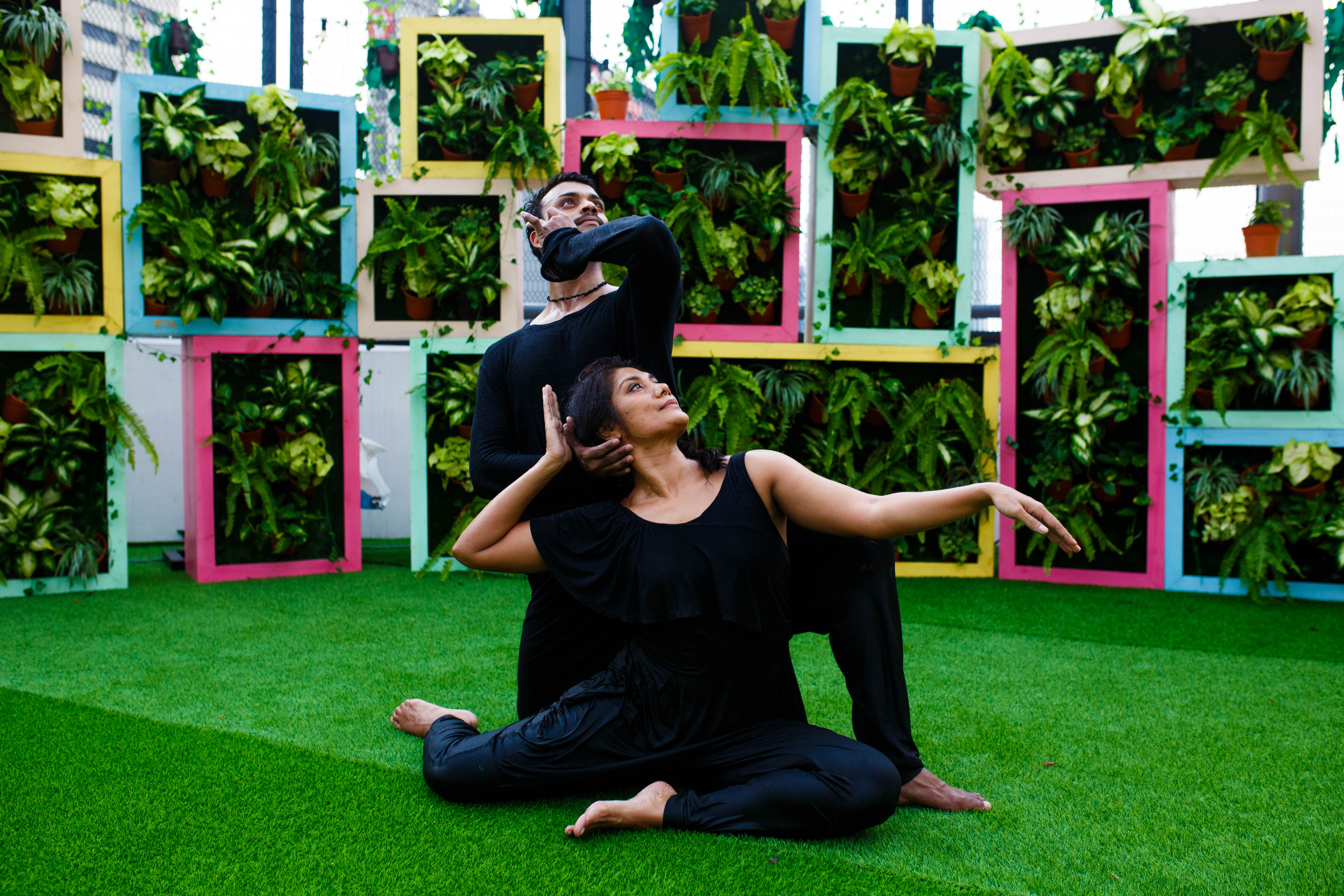Dancers against colourful geometric plant frames